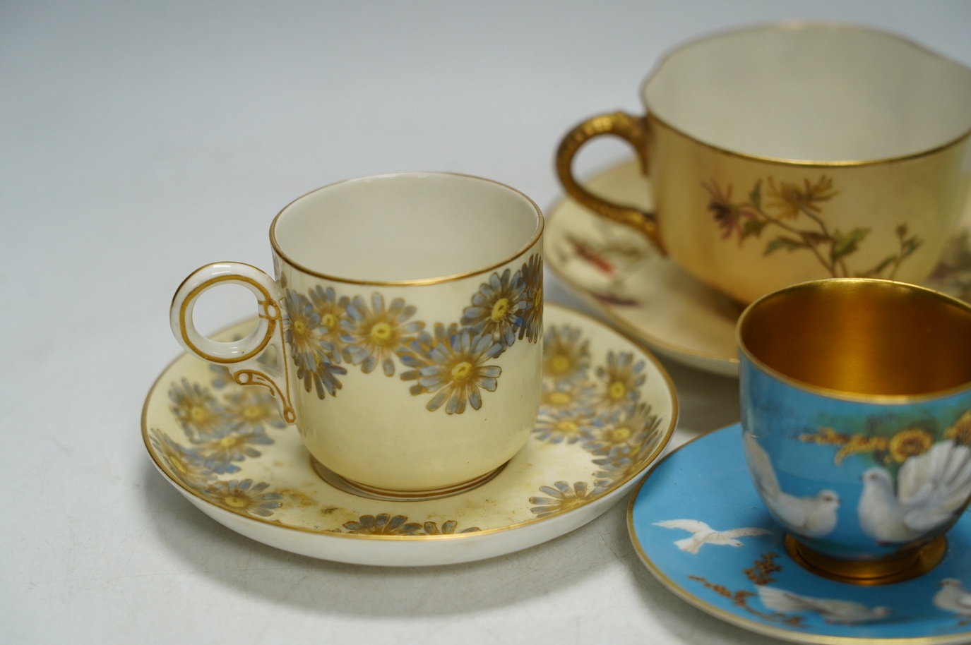 Four miniature Worcester cups and saucers, including a blush ivory ground, one signed G Johnson, largest 12.5cm wide. Condition - fair